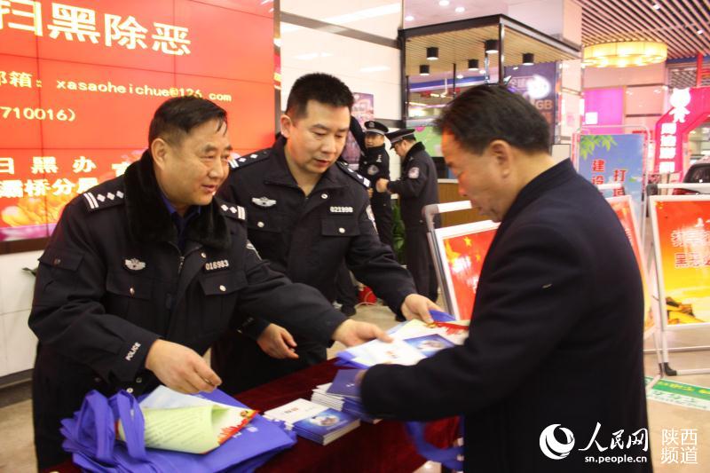 乔锦仁（左一）配合大队开展扫黑除恶宣传 图片由国保大队提供