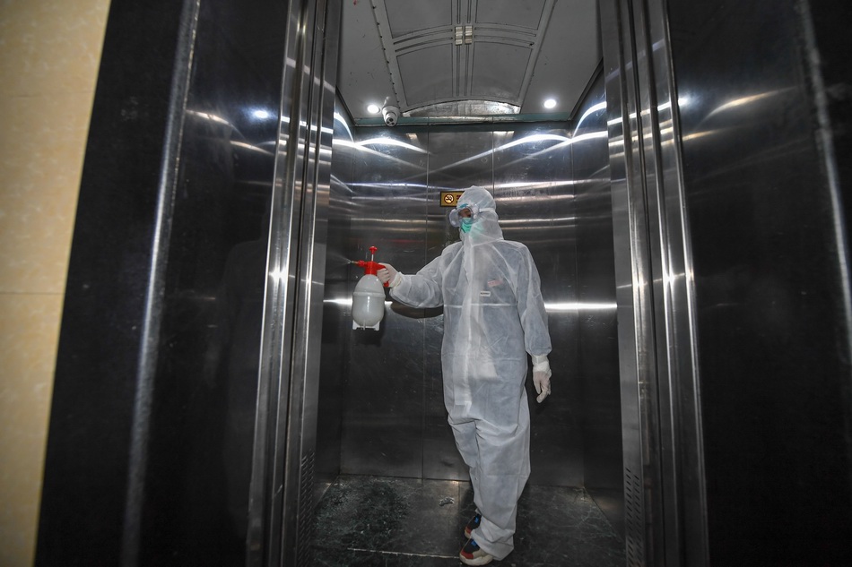 5月10日，在舒兰市一个小区，社区工作人员对电梯进行消毒。  新华社 图