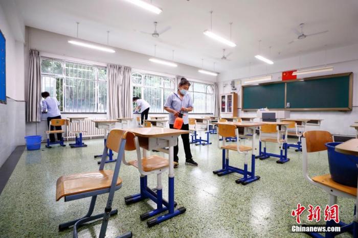 图为7月3日北京十二中保洁人员对考场及走廊进行清扫、消毒。 <a target=