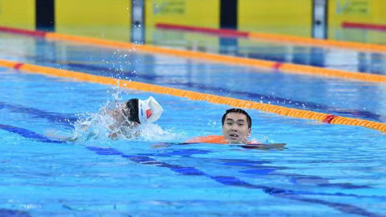特奥游泳比赛中救生员陪伴运动员游完最后80米