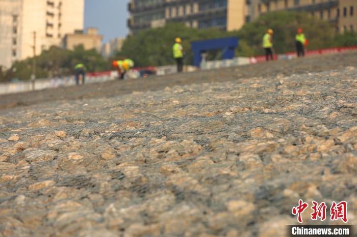 9月28日，长江九江城防堤段崩岸治理现场，一些工人在护坡上作业。 刘力鑫 摄
