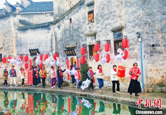 大年初一，游客和花灯队队员在黟县宏村月沼舞兔灯。 方龙 摄