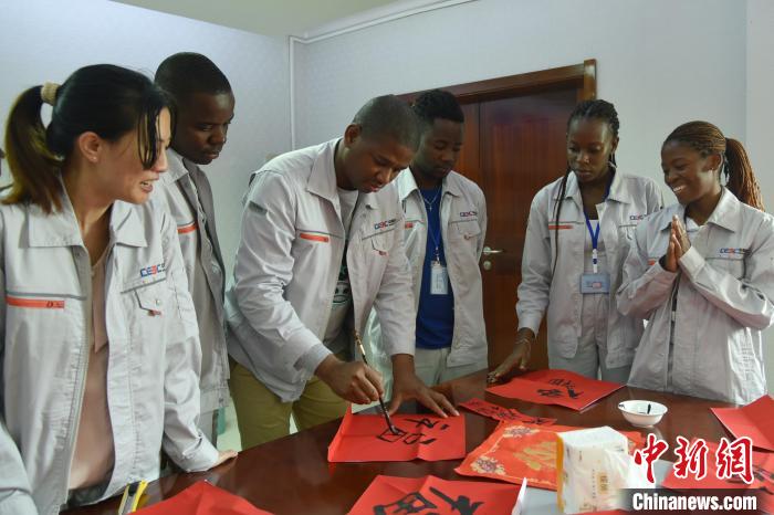 图为春节文化活动现场，中外员工体验写福字。 中国能建葛洲坝建设公司供图