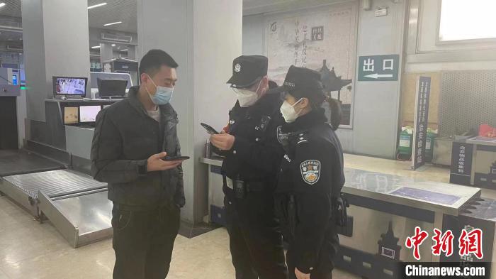 民警刘学强和李晨俊正在与旅客进行交流。 李小朋 摄
