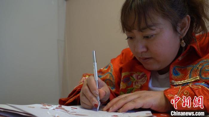 白丽玲手持刻刀,正在进行创作。 潘琦 摄 白丽玲手持刻刀,正在进行创作。 潘琦 摄