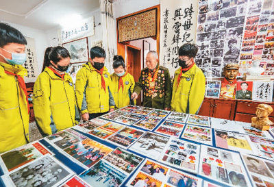 雷锋生前战友、江苏省南京市溧水区人武部退休老干部赵明才在家中为小朋友讲述雷锋故事。朱红生 摄（人民图片）