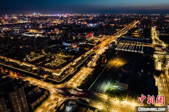 图为西安火车站与华灯初上的古城西安相映成辉。 刘翔 摄 图为西安火车站与华灯初上的古城西安相映成辉。 刘翔 摄