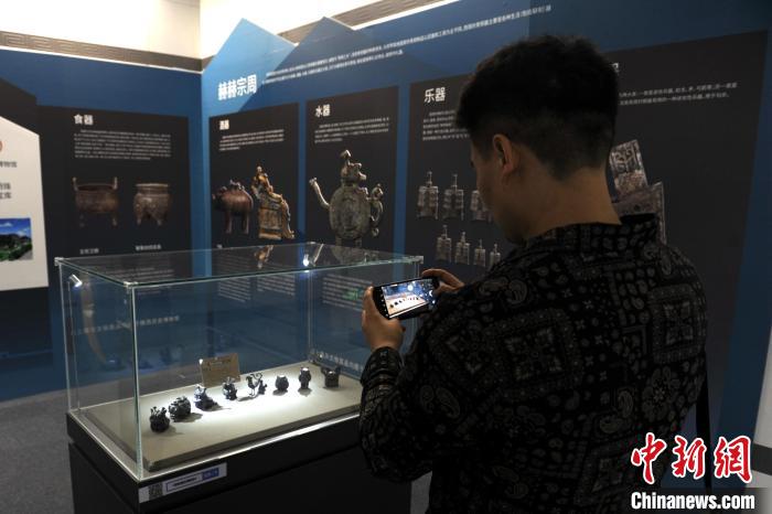 图为市民在行政中心站拍摄展品。 高铖 摄