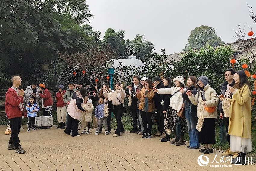 叶科(左一)给前来参与活动的“柑爸柑妈”介绍生态种植果。人民网记者朱虹摄