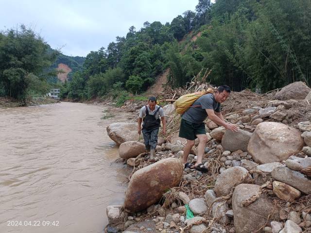 路被洪水冲毁，只能靠着河边的石头前进