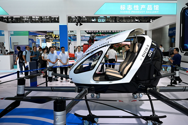 Visitors learn about an electric vertical takeoff and landing aircraft at the 2024 World Manufacturing Convention in Hefei, east China's Anhui Province, Sept. 20, 2024. (Xinhua/Huang Bohan)