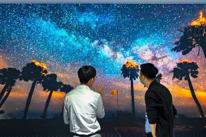 长春光博会希达电子展区，一位工作人员正在给一位观众讲解。（长春新区供图）