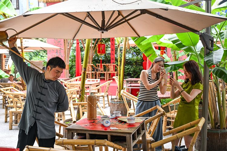Tourists take photos of tea art performance at a teahouse in Yuzhong District, southwest China's Chongqing Municipality, June 8, 2025. (Xinhua/Wang Quanchao)