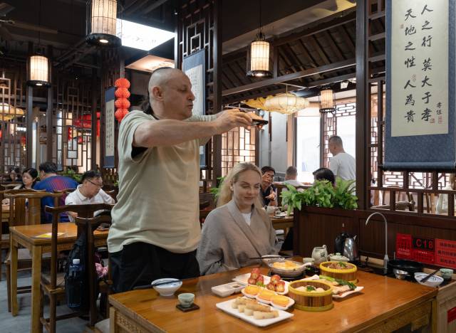 来自异国的“新”广州人亚诺士夫妇在越秀区叹早茶，他们对中国茶艺和糕点十分感兴趣。南方+记者 金镝 摄
