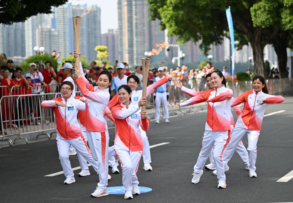 △粤剧表演艺术家曾小敏（左二）与外来务工人员方阵火炬手们在广州站传递活动中。新华社记者邓华摄