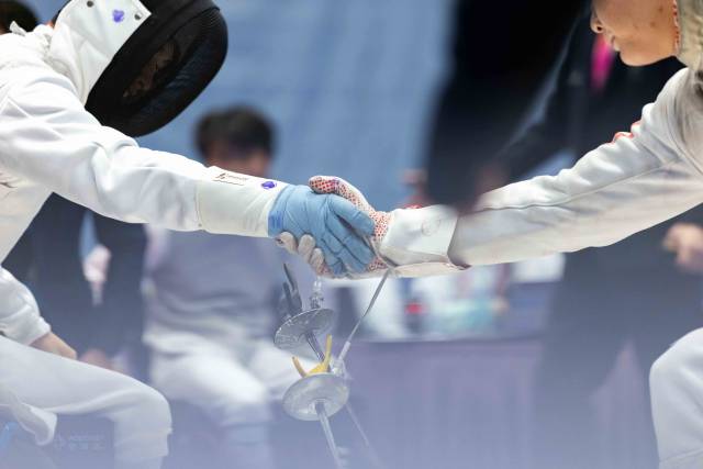 12月12日,在香港赛区男子花剑团体铜牌赛后,广东一团吴安迪(左)与对手握手。 12月12日,在香港赛区男子花剑团体铜牌赛后,广东一团吴安迪(左)与对手握手。