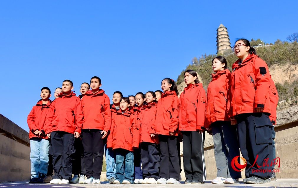 新疆学子在陕西延安宝塔山下朗诵诗歌《延安,我把你追寻》。人民网 李龙摄 新疆学子在陕西延安宝塔山下朗诵诗歌《延安,我把你追寻》。人民网 李龙摄