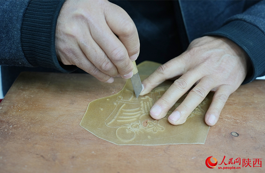 陈义文正在进行雕刻皮影。人民网记者 孙挺摄