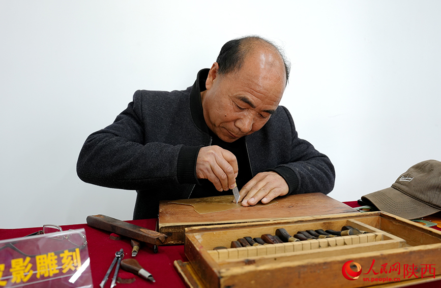 陈义文正在进行雕刻皮影。人民网记者 孙挺摄