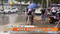 暴雨来袭  西安市民地铁站口等“摆渡”